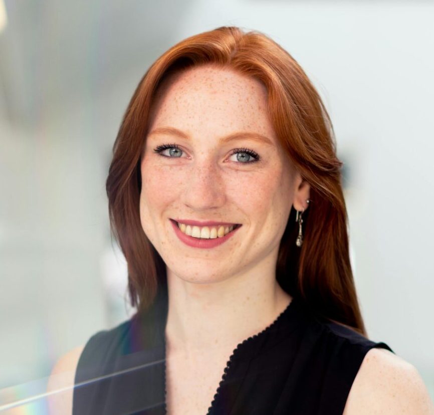 Confident businesswoman smiling in a bright modern office setting.